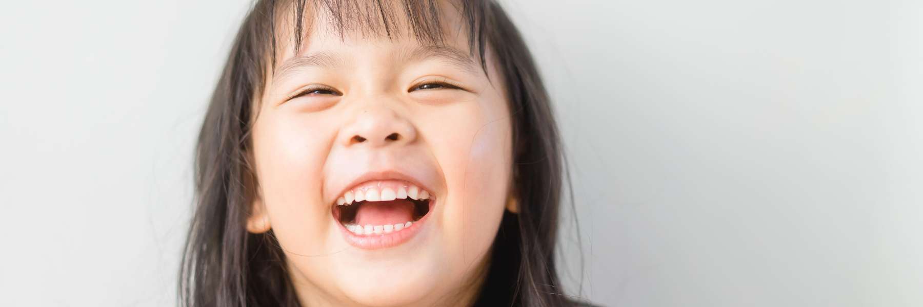Happy child showing healthy teeth after oral myofunctional therapy at Be Well Dental in Highgate Hil