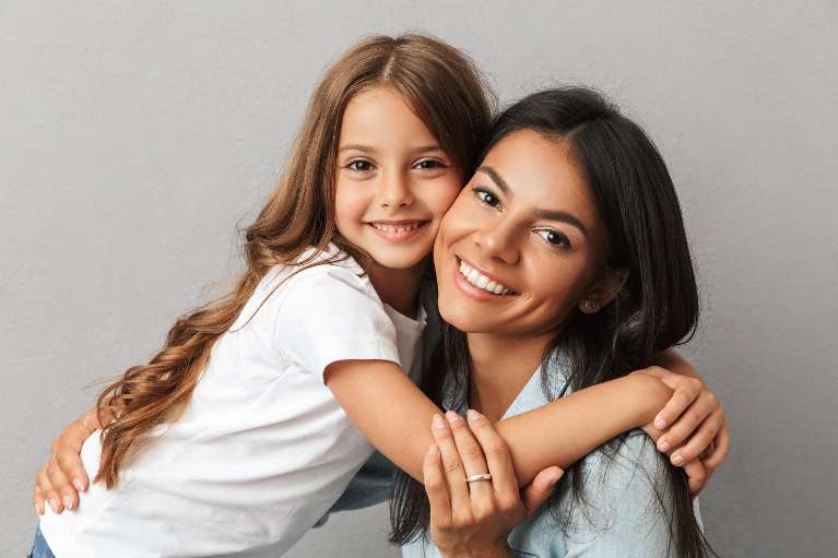 Happy mother and daughter smiling together after a positive, comfortable dental visit