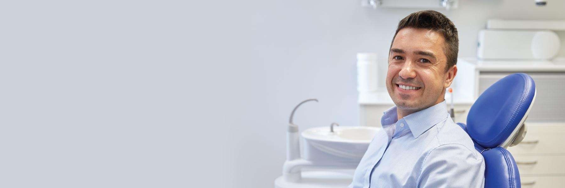 Smiling patient relaxed in dental chair after a comfortable, stress-free visit