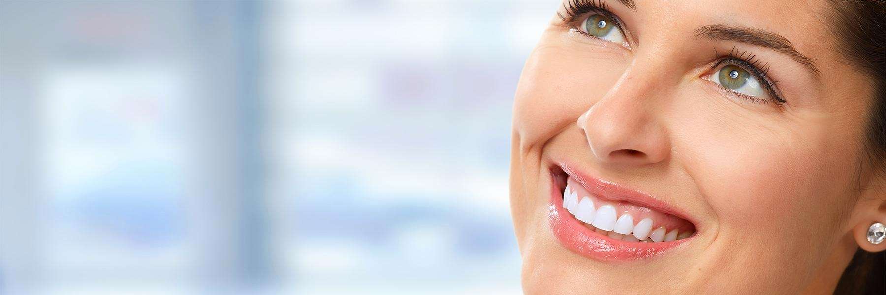 Woman smiling with bright white teeth after professional whitening treatment